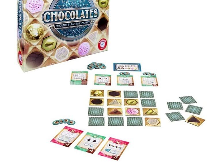 Joc de societate Chocolates - PIATNIK - - Deschideti cutia cu “bomboane” si aflati cate bomboane de ciocolata alba sunt in cutie si cate in afara ei? Sunt mai multe bomboane triunghiulare decat cele rotunde sau hexagonale? Raspundeti cat mai precis posibil