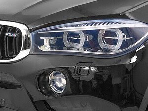 Pod respirator BMW X6M, în prim-plan, cu faruri LED și grilă specifică.