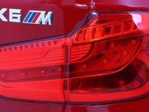 Led de semnalizare și stopuri pe mașina BMW X6M roșie.