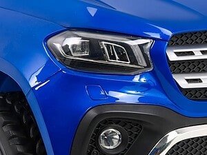 1. Capot de mașină albastră, focalizare pe farul și grila frontală.