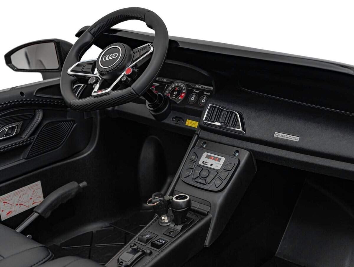 Volan sportiv cu emblemă Audi, interior elegant și detalii tehnologice moderne în mașina de lux.