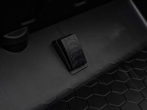 Pedal accelerator negru în mașină, focus pe pedală și covoraș negru.