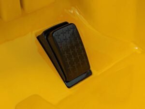 1. Pedale pentru mașinuțe de copil din plastic negru pe fundal galben vibratil.