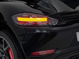 Mașină sport neagră, faruri LED și roți sport cu logo Porsche.