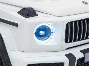 Jucărie auto Mercedes-Benz pentru copii, detaliu cu far și grilaj, perfectă pentru distracție.