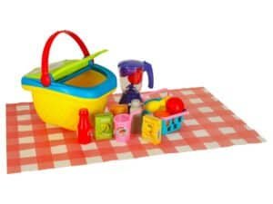 1. Jucării de plajă pentru copii, nisip și fructe, pe pătură cu dicționar pentru joacă creativă.