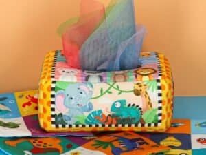 Colorful plush tissue box cover with jungle animals, perfect for children's room decor.