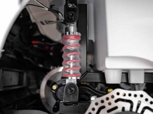 Suspensie pentru mașini electrice, în culoare roșie și negru, cu detalii tehnice și mecanice.