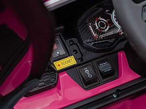 Jucărie de mașină electrică pentru copii, detalii interioare și panou de control colorat roz.