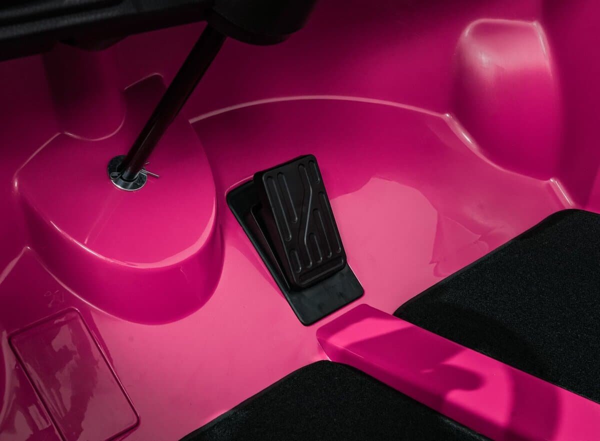 Piciorus pentru acceleratie si pedala de frana pe masina de joc pentru copii de culoare roz.