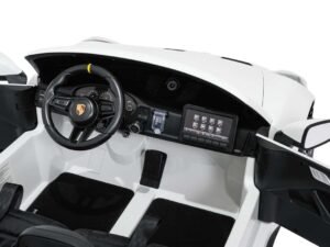 White toy car interior with Porsche steering wheel and dashboard display.