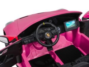 Mașinuță electrică pentru copii, interior detaliat, volan, ecran și design sportiv roz.